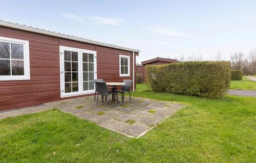 a patio with a table and chairs in a yard at 2 Bedroom Cozy Home In Wagenborgen in Wagenborgen