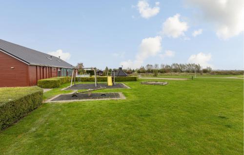a grassy yard with a playground in front of a building at 2 Bedroom Cozy Home In Wagenborgen in Wagenborgen