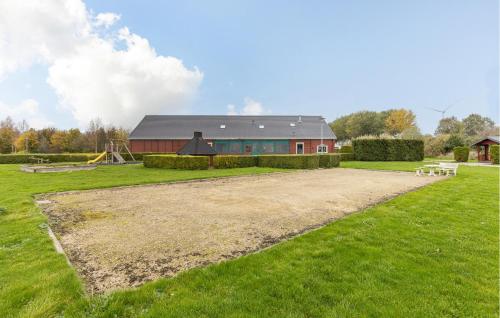 a barn with a playground in front of a field at 2 Bedroom Cozy Home In Wagenborgen in Wagenborgen