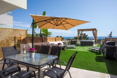 a patio with a table and chairs and an umbrella at Zafora Garden in Koskinou