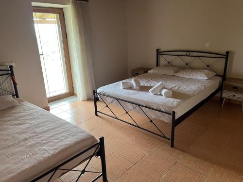 a bedroom with two beds and a window at Cozy Countryside Home in Vurgu i Ri