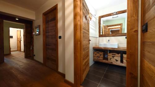 a bathroom with a sink and a mirror at Hostdomus - Flower Loft in Cesana Torinese