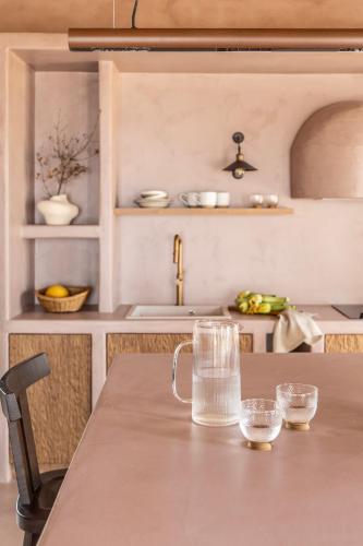 a table with a jug and glasses on it in a kitchen at Terracotta Fiscardo Villas in Fiskardho