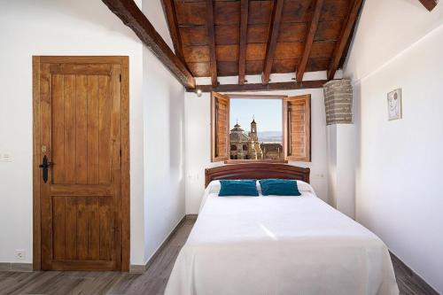 a bedroom with a bed and a wooden door at PUSHE Village Albayzin Art & Culture in Granada