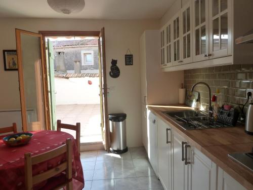 une cuisine avec un évier et une table avec un chiffon rouge dans l'établissement Charming Marseillan House with Great Location, à Marseillan