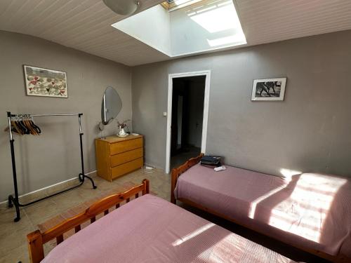 une chambre avec deux lits et une lucarne dans l'établissement Charming Marseillan House with Great Location, à Marseillan