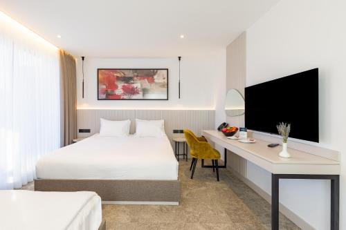 a hotel room with a bed and a desk at Regnum Banya Thermal Hotel in Banya