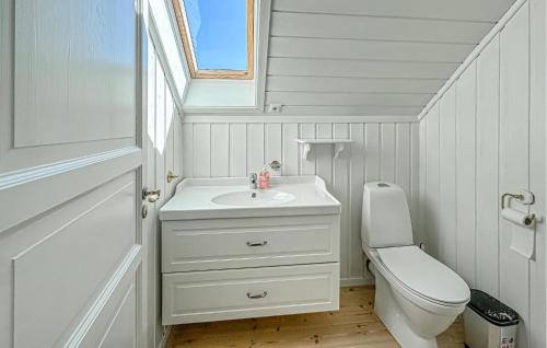 a white bathroom with a sink and a toilet at 4 Bedroom Cozy Home In Gjeving in Gjeving