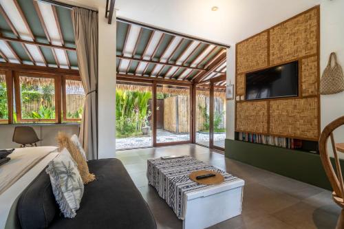 ギリ・アイルにあるVilla Maiyaのソファとテレビのあるリビングルーム