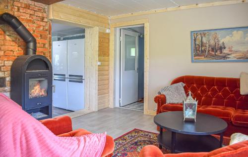 a living room with a fireplace and a red couch at 3 Bedroom Beautiful Home In Jämshög in Jämshög