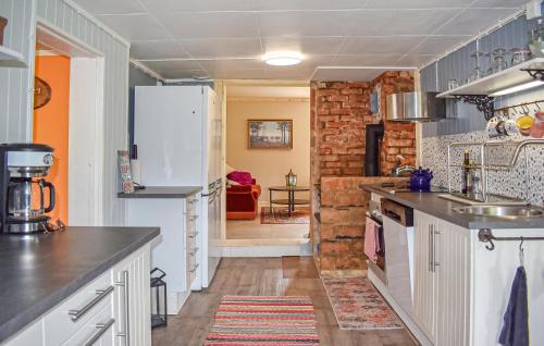 a kitchen with white cabinets and a brick wall at 3 Bedroom Beautiful Home In Jämshög in Jämshög
