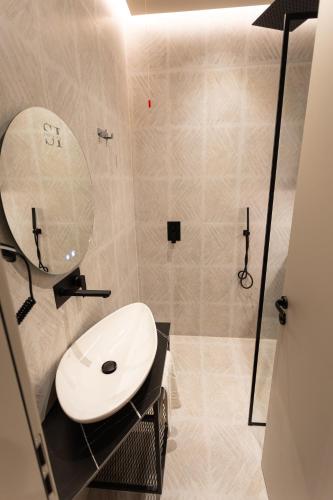 a bathroom with a white sink and a mirror at South Inn Hotel in Vlorë