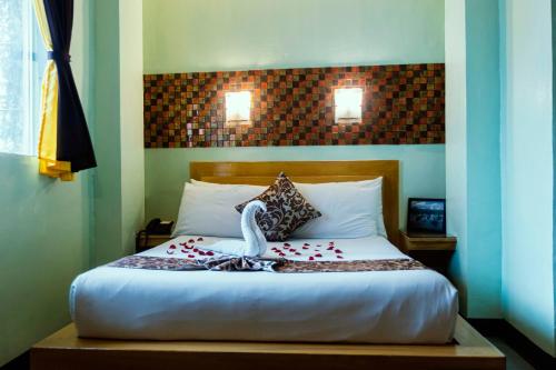 a bedroom with a bed with a swan on it at St Illians Inn Makati in Makati