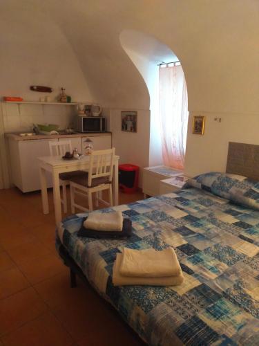 a bedroom with a bed and a table and a kitchen at B&B Antico Castello in Seborga