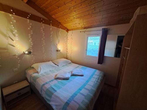 a small bedroom with a bed with towels on it at Chalet Domaine de la Forge in La Teste-de-Buch