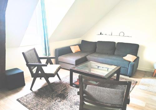 un salon avec un canapé, une table et des chaises dans l'établissement Le Duplex de Trouville - central - gare - commerces - marché, à Trouville-sur-Mer