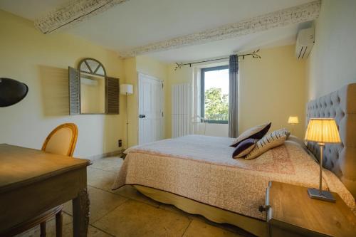 a bedroom with a large bed with a window at La Belle Vie in Saint-Hilaire-dʼOzilhan