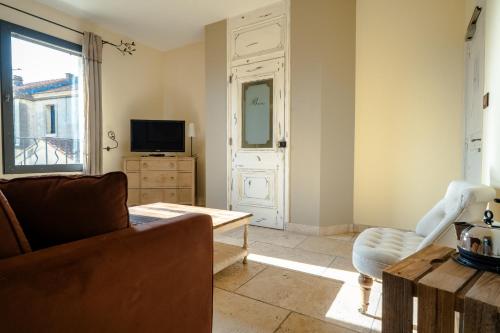 a living room with a couch and a television at La Belle Vie in Saint-Hilaire-dʼOzilhan