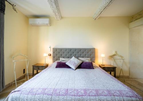 a bedroom with a large bed with two night stands at La Belle Vie in Saint-Hilaire-dʼOzilhan