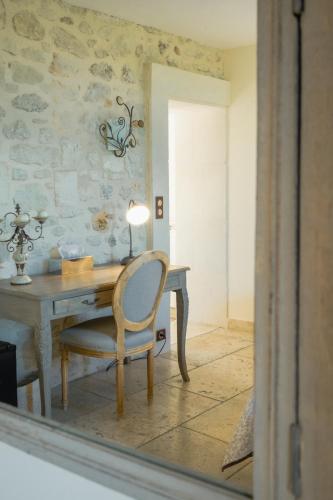 a desk with a chair and a table with a lamp at La Belle Vie in Saint-Hilaire-dʼOzilhan