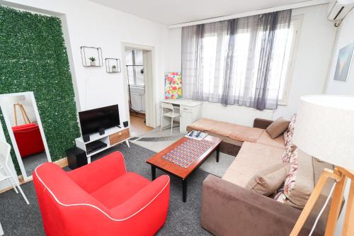 a living room with a couch and a red chair at Fantazy Apartment Main Square in Skopje
