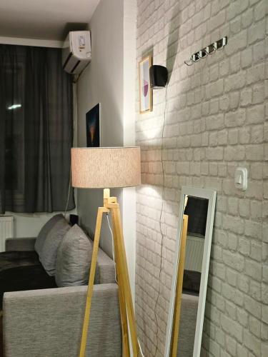 a lamp in a room with a bed and a mirror at Mother Teresa Apartments in Skopje