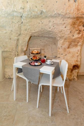 een tafel en stoelen met een bord eten erop bij B&B Palazzo Diamante in Gravina in Puglia