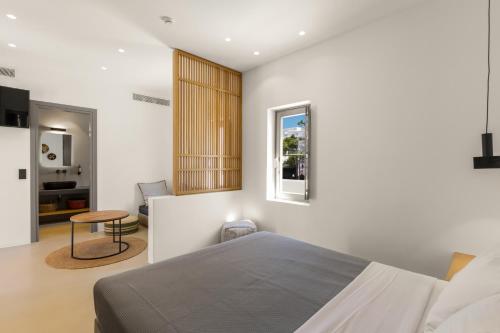 a bedroom with a bed and a table and a window at Clementina Paros in Naousa