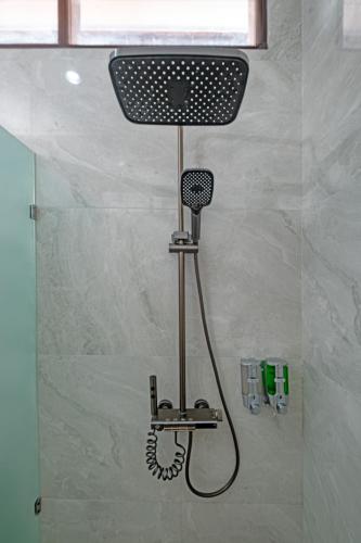 a shower with a blow dryer in a bathroom at Kemala Living Sanur in Sanur