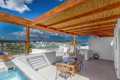 a roof deck with a table and chairs and a pool at Clementina Paros in Naousa