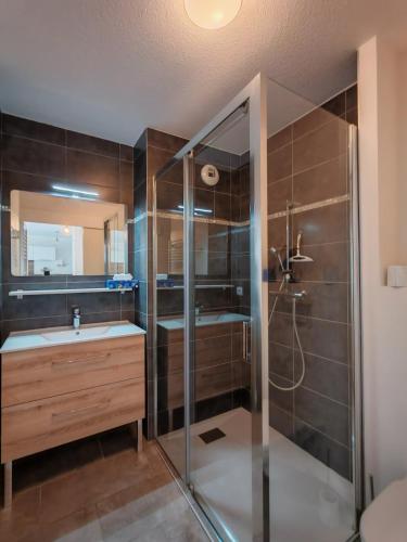 une salle de bain avec une douche, un lavabo et un miroir dans l'établissement Appartement avec jardin, à Saint-Gervais-les-Bains
