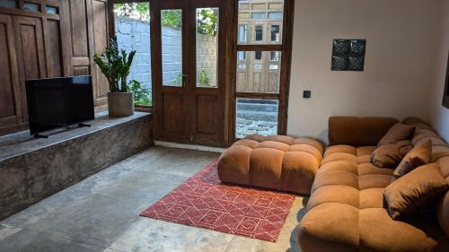 a living room with a couch and a flat screen tv at NEW The Loft - Uluwatu Surf Ranch in Uluwatu