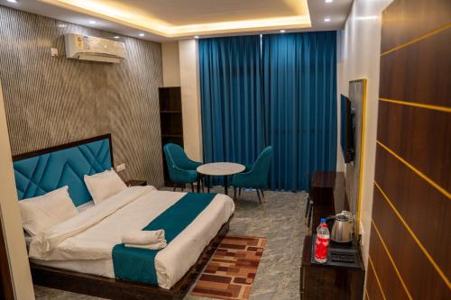 a hotel room with a bed and a table and chairs at Aroma & U in Kūfrī