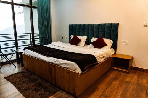 a bedroom with a large bed with a green headboard at Aroma & U in Kūfrī