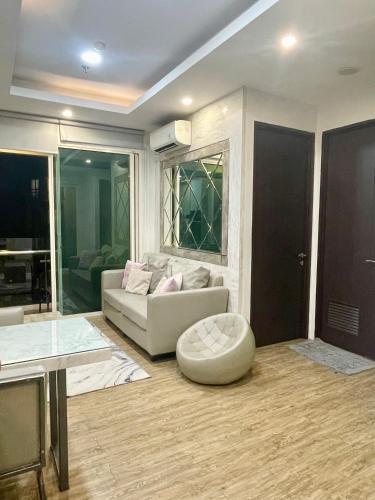 a living room with a white couch and a table at 2BR Peaceful & Cozy Family Condo in Jakarta