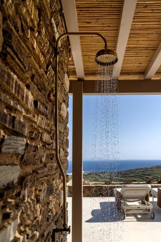 an outdoor shower with a view of the ocean at Soborgo Exquisite Villas in Tinos Town