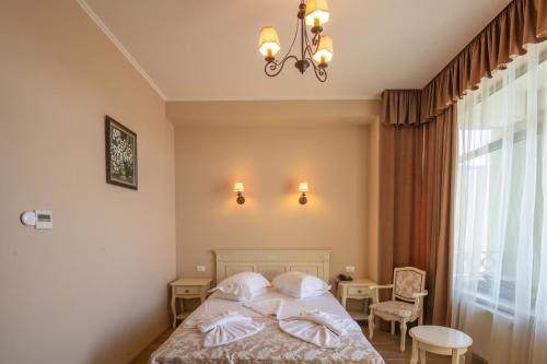 une chambre avec un lit et un lustre dans l'établissement Complex Verona Mamaia Nord, à Mamaia Nord – Năvodari