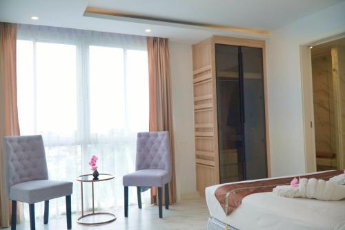 a bedroom with a bed and two chairs and a table at D Eco Wellness Center in North Pattaya