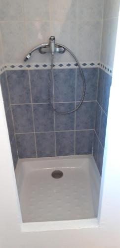a bath tub with a shower with a shower head at La Maison Des Autres, piscine chauffée, chambres d'hôtes proches Uzès, Nîmes, Pont du Gard in Saint-Géniès-de-Malgoirès