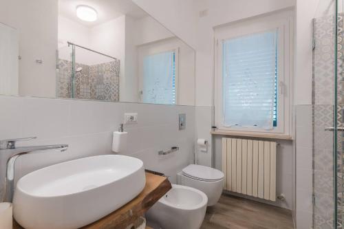 a white bathroom with a sink and a toilet at Villa Matilde only 10 min from the beach in Novilara