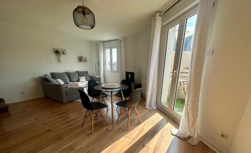 un salon avec une table, des chaises et un canapé dans l'établissement Le 203 - 4 Personnes - Gare, au Mans