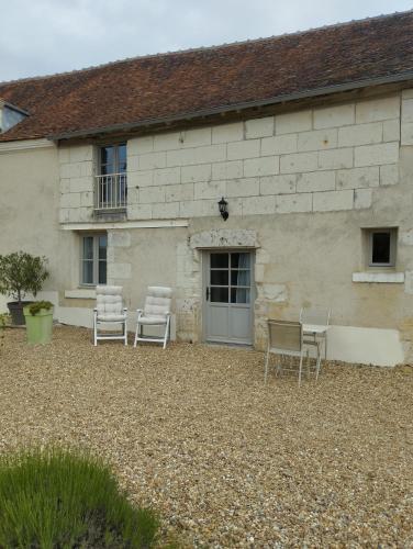 a group of chairs sitting outside of a building at Maison dans belle longère - La Serrerie in Thenay