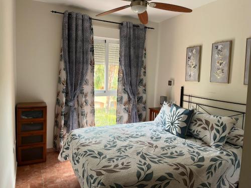 a bedroom with a bed and a ceiling fan at Ático dúplex con piscina privada y vistas al mar en Paraíso de Vera! in Vera