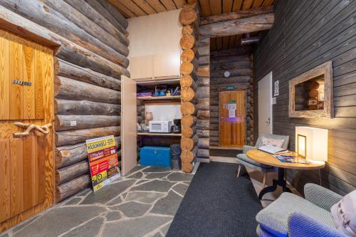 a room in a log cabin with a table and a kitchen at Kuukkeli Log Houses Teerenpesä in Saariselka