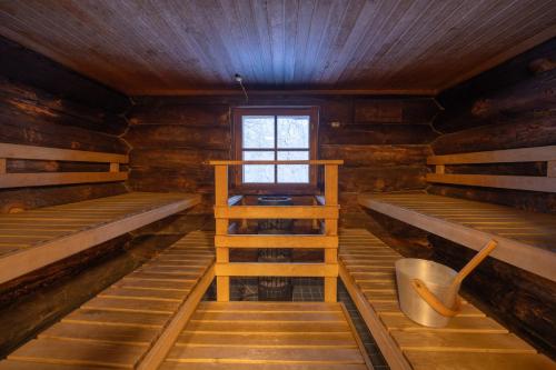 a room with two bunk beds and a window at Kuukkeli Log Houses Teerenpesä in Saariselka