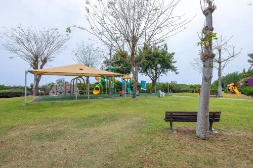 a park with a bench next to a tree at נאות גולף קיסריה - דירות מהממות עם ג'קוזי ובריכה במתחם in Caesarea