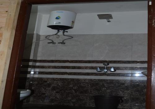 a bathroom with a shower with a toilet and a sink at Green valley homestay in Khajjiar 
