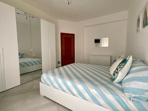 una camera da letto bianca con un letto e uno specchio di Casa Marea - Lerici Center a Lerici