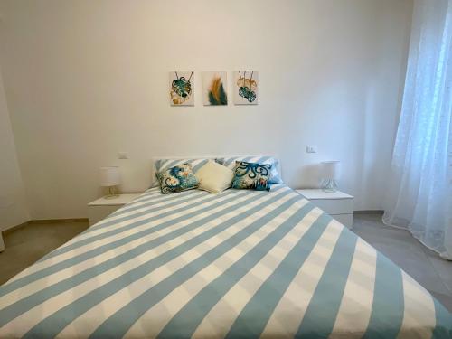 una camera da letto con un grande letto a strisce blu e bianche di Casa Marea - Lerici Center a Lerici