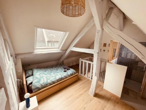 - une petite chambre mansardée avec un lit et une fenêtre dans l'établissement Notre coin secret - Jolie duplex au fil du Robec - 386, à Rouen